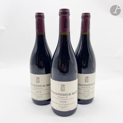trois bouteilles de vin rouge sont alignées sur une surface blanche