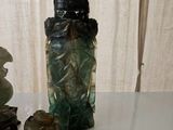 a glass bottle with a statue on it next to other items