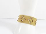 a close up of a mannequin head with a gold bracelet on it