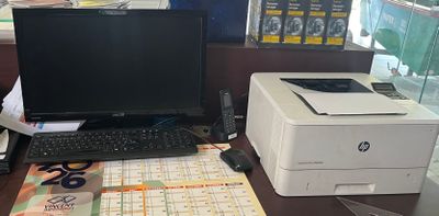 a desk with a laptop, printer, and a printer on it