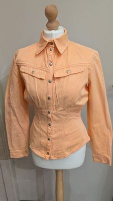 une veste pour femme posée sur un mannequin dans une pièce