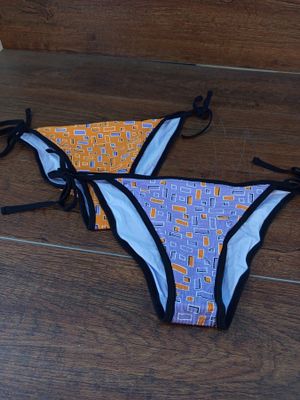 deux bikinis avec des liens, posés sur un plancher en bois