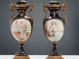 pair of antique vases with painted scenes on them sitting on a table