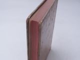 a small red book sitting on a white surface