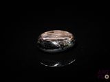 une photo d'une bague posée sur une surface noire