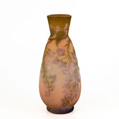 un vase en verre orné de fleurs, posé sur une surface blanche