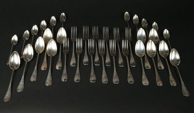 beaucoup de cuillères et de fourchettes disposées ensemble sur une table