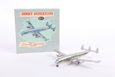 a toy airplane that is sitting next to a book
