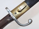 a close up of a sword on a white surface