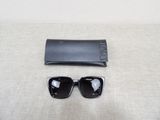black sunglasses and a black case on a white surface