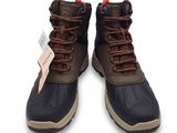 une paire de bottes marron et noires avec des lacets marron sur fond blanc
