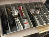 a drawer with utensils and knives in it