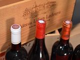 several bottles of wine are lined up in a wooden box