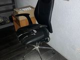 a black office chair sitting in front of a bulletin board