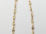 un collier à chaîne en or avec un maillon allongé sur fond blanc