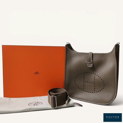 an orange box with a belt and a grey bag with a silver buckle