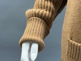 an image of a mannequin wearing a brown sweater and gloves