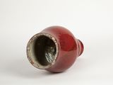 a red vase that is sitting on a white surface