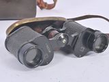 a pair of binoculars sitting on a table next to a purse