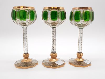 three green glass goblets sitting next to each other on a white surface