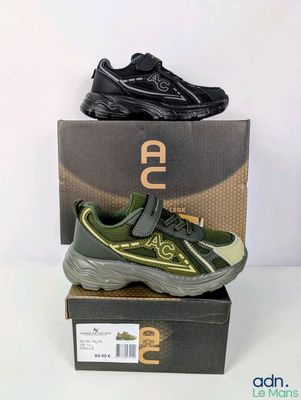 a pair of black and green sneakers on top of a box