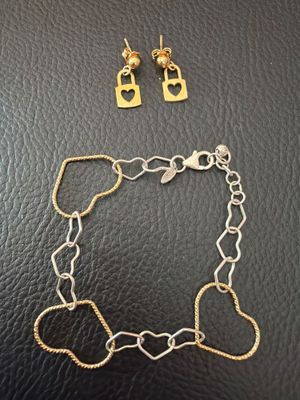 a pair of gold and silver bracelets with heart charms