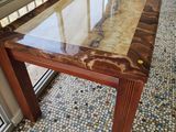 a glass table with a marble top on a tiled floor
