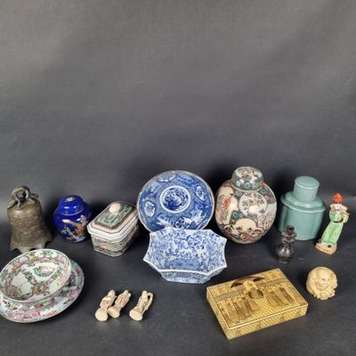 Divers vases et figurines chinois sont exposés sur un fond noir.