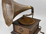 un vieux gramophone posé sur un support en bois, avec un fond blanc