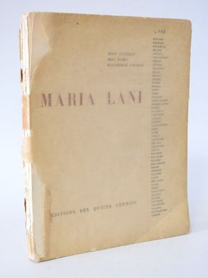 an old book sitting on top of a white table next to a white wall