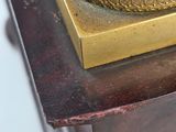 a gold clock sitting on top of a wooden table