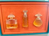 three bottles of perfume sitting on a red tray