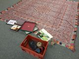 un tapis et une boîte de livres posés par terre
