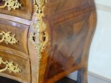 a wooden chest of drawers with a marble top