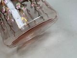 a glass vase with a bird on it sitting on a table