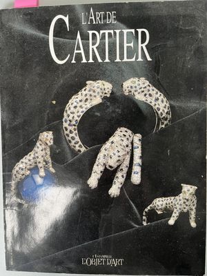 the book is sitting on a table next to a pair of earrings