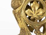 a gold vase with a bird on it on a white surface
