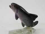 statue of a fish on a rock on a white surface