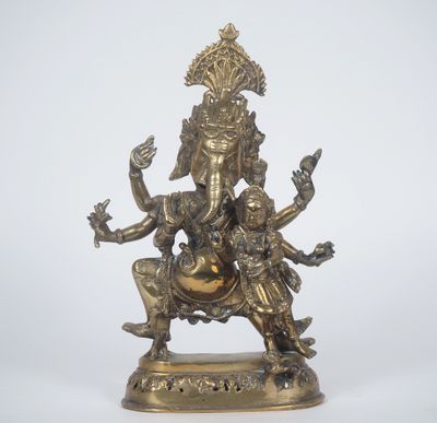 une statue en bronze représentant une femme assise sur une chaise