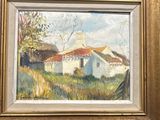 une peinture à l'huile représentant une maison blanche au toit rouge, dans un cadre doré