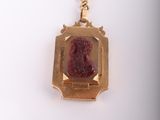 an image of a gold keychain with a picture of a woman on it