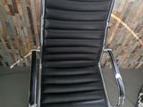 a black leather office chair sitting in front of a window