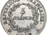 a silver coin with a wreath on the front of it