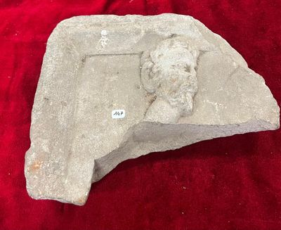 une sculpture en pierre représentant un chien posée sur un tissu rouge