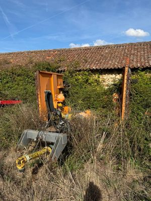 a tractor that is sitting in the grass near a building