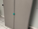 une armoire munie d'une poignée bleue dans une salle de bains