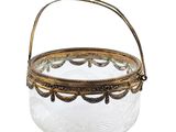 un petit panier en verre orné d'une bordure dorée et muni d'une poignée