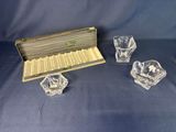 a set of four glass candlesticks and a box