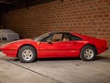 a red sports car parked in a garage next to a brick wall