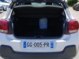 the back of a white car with its trunk open in a parking lot